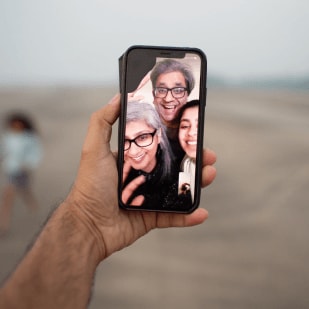Man holding phone during FaceTime call with family